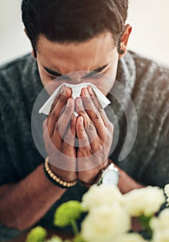 Face, hand and blowing nose with a man using a tissue in his home for relief from allergy symptoms. Sick, cold or flu