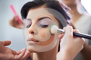 Face, hands and woman with makeup application and beauty, brush for color powder and glamour with beautician. Eyeshadow