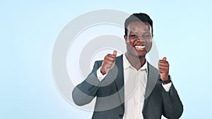 Face, happy and a black man with a thumbs up on a studio background for corporate success. Excited, thank you and