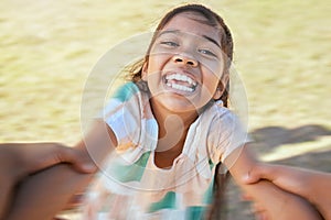 Face of happy girl swinging and spinning in circles by the arms at the park with his father. Cute playful kid having fun