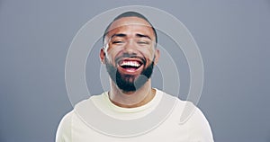 Face, happy or man laughing at a funny joke or crazy humor in studio isolated on gray background. Freedom, excited model