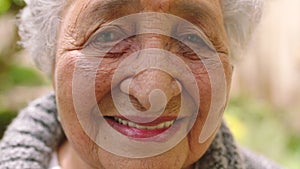 Face, happy and smile with a senior woman standing outside in the garden of her assisted living home. Closeup portrait