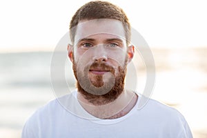 Face of happy smiling young man on beach