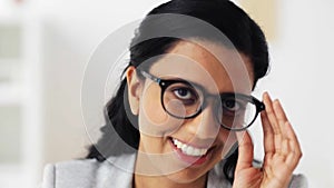 Face of happy smiling young woman in glasses