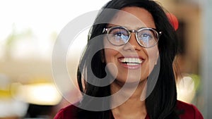 Face of happy smiling young woman in glasses