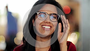 Face of happy smiling young woman in glasses