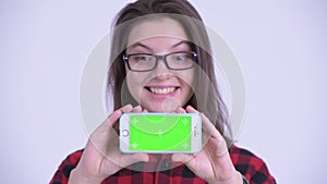 Face of happy young beautiful hipster woman showing phone