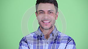 Face of happy young handsome Hispanic man smiling