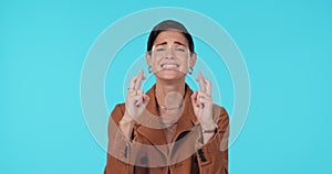 Face, hope and woman with fingers crossed, praying and promotion against a blue studio background. Portrait, female