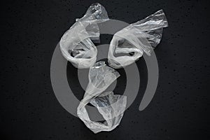 Face laid out of empty plastic bags on a dark background. The concept of consumption and pollution of environment