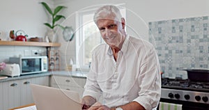 Face, laptop and senior man in home, typing and reading email on technology at table in kitchen. Portrait, smile and