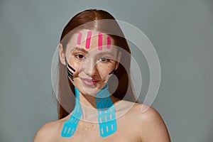 Face lift tape. Facelifting patches stickers for rejuvenating. Redhead girl satisfied with using of anti wrinkle tapes