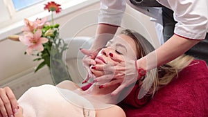 Face lifting and body massage to beautiful girl in cosmetology cabinet or beauty parlor. HD