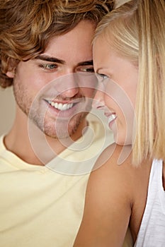 Face, love and smile with a young couple closeup in their home together for romance or bonding. Relax, happy or dating