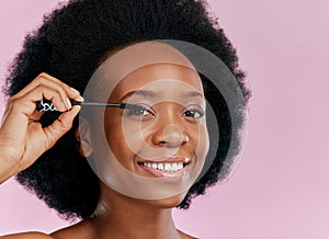 Face, makeup and black woman with mascara, smile and beauty in studio isolated on a pink background mockup. Portrait
