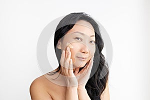 Face Makeup. Closeup Of Beautiful Asian Woman Hand Applying Foundation On Facial Skin.