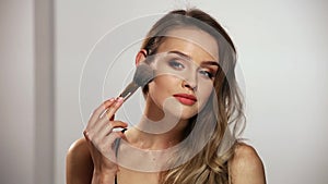 Face Makeup. Smiling Woman Applying Powder On Skin