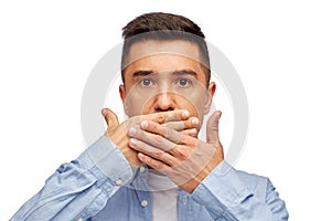 Face of man covering his mouth with hand palm