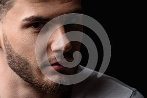 Face of a man looking into the camera from darkness