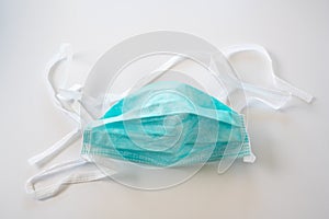 Face mask against droplet infection of contagious disease like coronavirus, light gray background, copy space