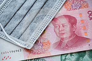 Face mask on Chinese renminbi yuan banknote background. Global novel coronavirus Covid-19 outbreak effect to world economy