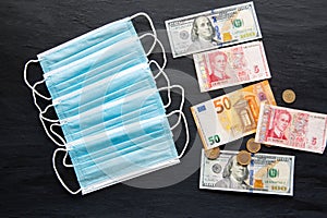 Face mask and euro, dollar and lev banknotes. Charges for medical masks because of Coronavirus pandemic. Concept of medical costs