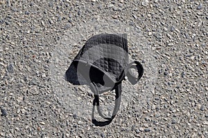 Face mask on floor in street. Improperly discarding used face mask.