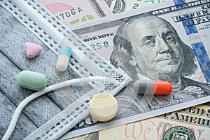 Face mask and medicine pill, tablets on US dollar bill banknote background.