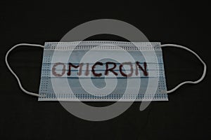 A face mask with the name of the new variant of covid-19, Omicron. Coronavirus concept