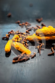 Face mask or packâ€™s ingredients on the wooden surface for acne which are turmeric or Haldi and cloves. Ingredients spread