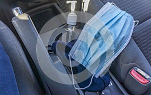 Face mask and sanitizer dispenser inside a car