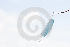 A face mask tied in a branch