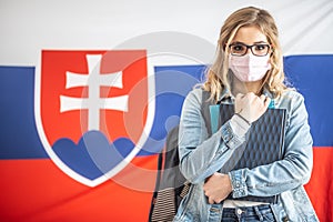 Face mask wearing student teenager with Slovak flag in the background