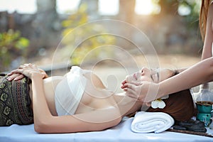 Face massage, 2 beautiful and sexy asian young woman in white dress enjoying oil spa massage salon during sunny day with happy