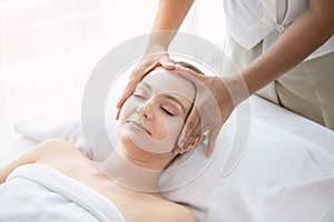 Face massage. Attractive beautiful young woman relax lying on massage bed in spa salon. Spa aroma therapy and massage facial