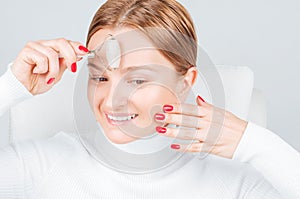 Face massage. Beautiful woman getting massage forehead using roller massage