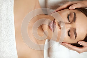 Face massage. Beautiful woman getting spa massage treatment at beauty spa salon