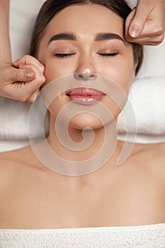 Face massage. Beautiful of young woman getting spa massage treatment at beauty spa salon.Spa skin and body care.