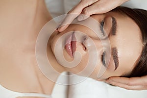 Face massage. Beautiful of young woman getting spa massage treatment at beauty spa salon.Spa skin and body care.