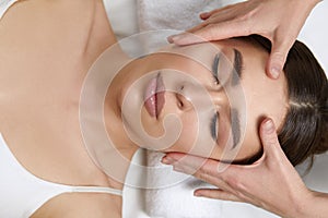 Face massage. Beautiful of young woman getting spa massage treatment at beauty spa salon.Spa skin and body care.