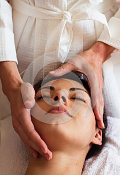 Face Massage. Close-up of a beautiful Woman Getting Spa Treatment.