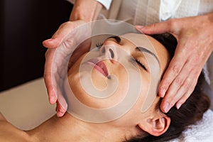 Face Massage. Close-up of a beautiful Woman Getting Spa Treatment.
