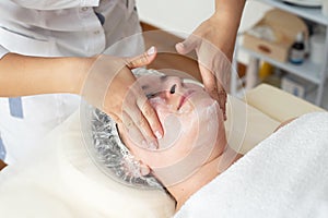 Face massage. Close-up of woman getting spa massage treatment at beauty spa salon. Spa skin and body care.