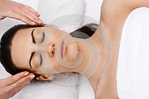 Face massage.  Close-up of young woman getting spa massage treatment at beauty spa salon.Spa skin and body care. Facial beauty