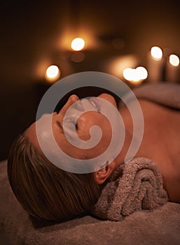 Face massage, spa and wellness with woman, luxury and candle with hospitality and peace. Person, facial and girl with