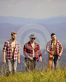 Face the music. western camping. campfire songs. hiking adventure. cowboy men. happy men friends with guitar. friendship