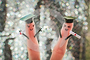 Face painted on the fingers. students holding their diploma after graduation