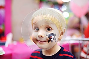 Face painting for cute little boy during kids birthday party