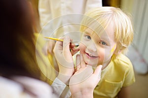 Face painting for cute little boy during kids merriment