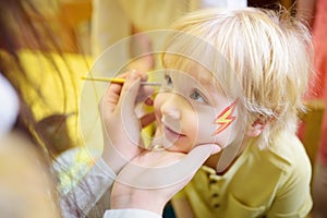 Face painting for cute little boy during kids merriment